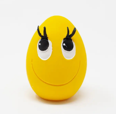 Yellow egg-shaped dog toy with black antennae on a white background