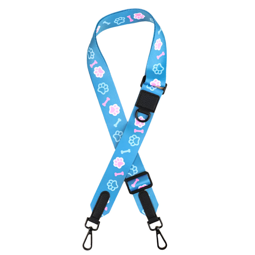 A blue walking bag strap featuring a pattern with paws and bone illustrations, and adjustable straps with buckles.