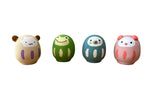 Four colorful rubber animals on a wooden surface