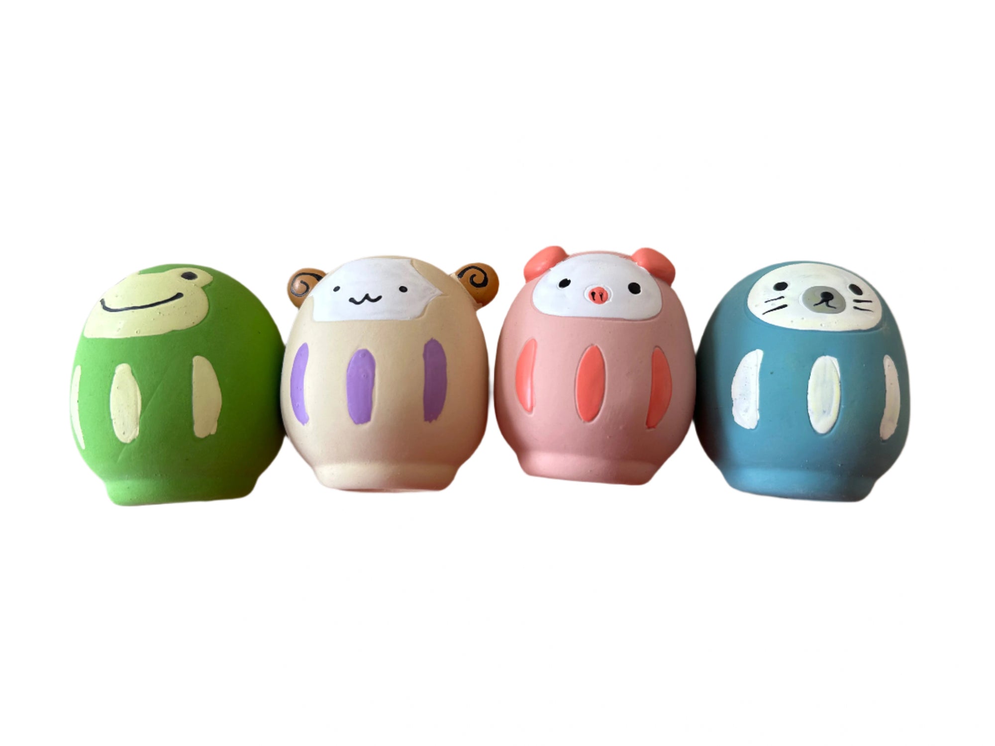 Four colorful animal-shaped containers on a wooden surface