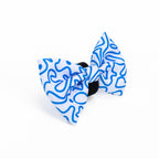 A blue and white swirly patterned bow tie designed for dogs, displayed on a white background.