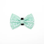 Green bow tie with white patterns on a white background