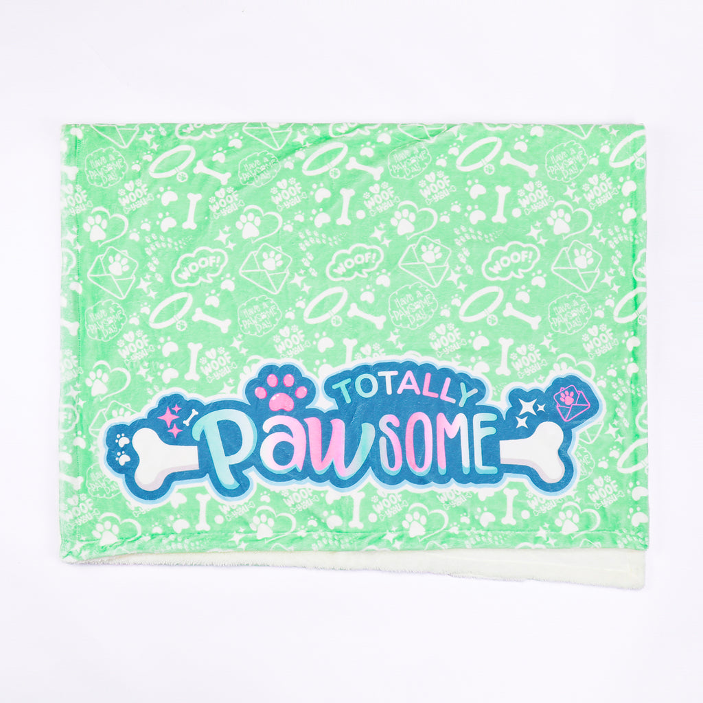 blanket with 'Totally Pawsome' text and paw prints on a green background
