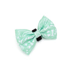 Green bow tie with white patterns on a white background