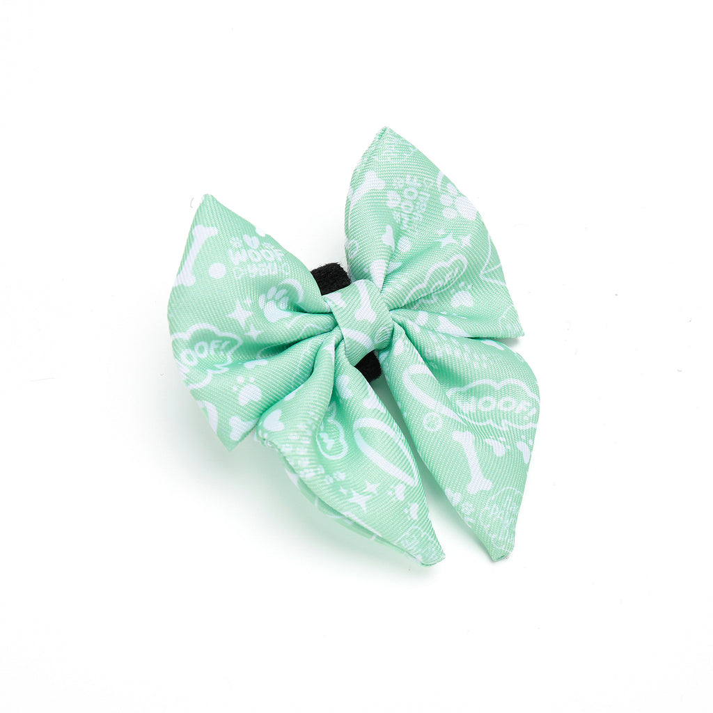 Light green dog bow tie with white patterns on a white background