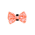 An orange bow tie for dogs with a paw print pattern on a white background.