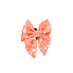 Large orange bow with white patterns on a white background