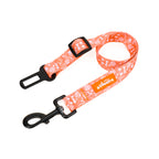 An orange seat belt restraint with a floral pattern and a label that reads 'TP ADVENTURES'.