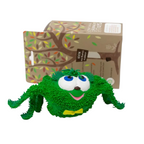 Green rubber toy with a box featuring a tree design in the background