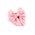 Pink bow with white patterns on a white background