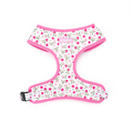 Floral patterned dog harness with pink trim on a white background