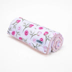 Rolled-up blanket with floral pattern on a white background