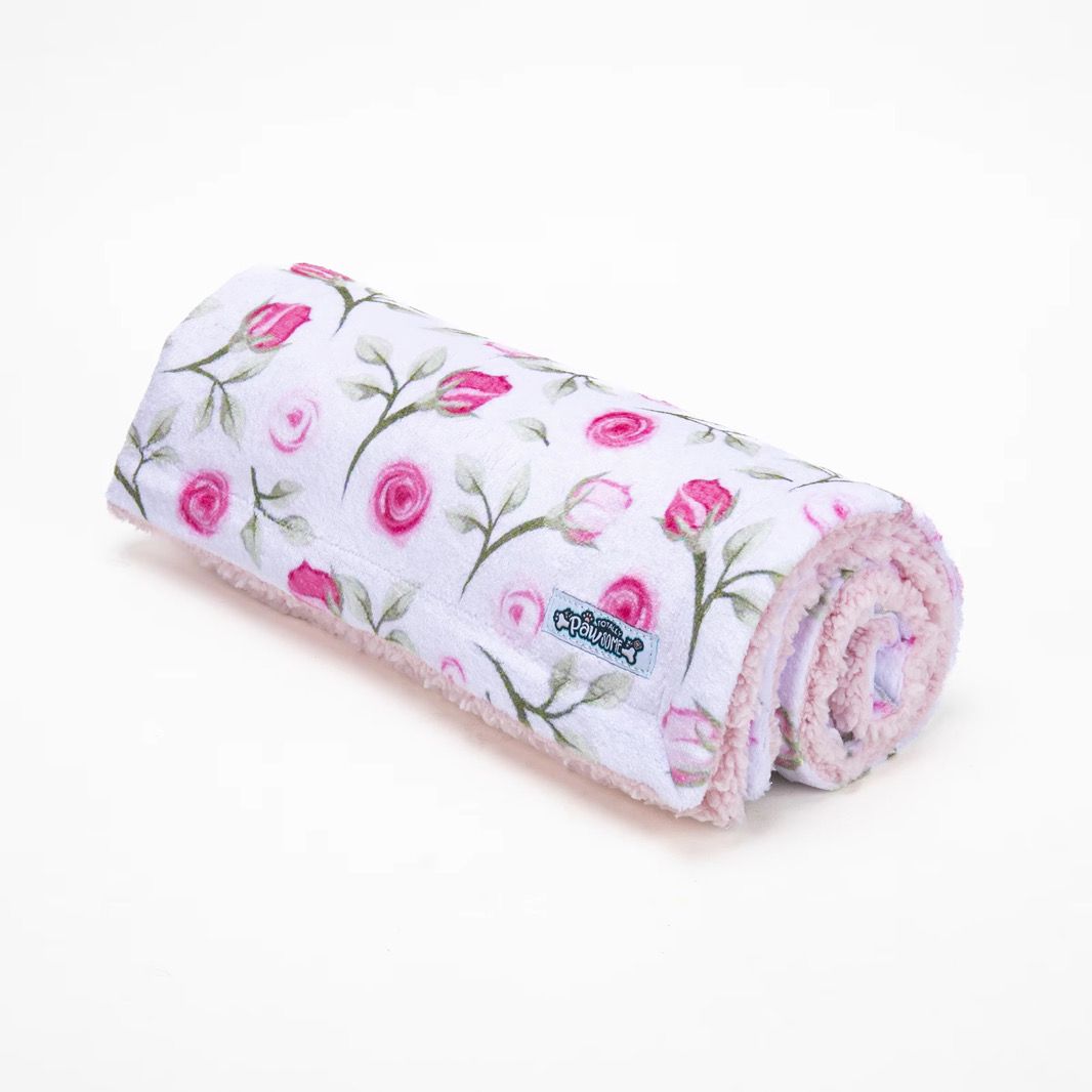 Rolled-up blanket with floral pattern on a white background