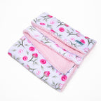Floral patterned blanket with pink edges on a white background