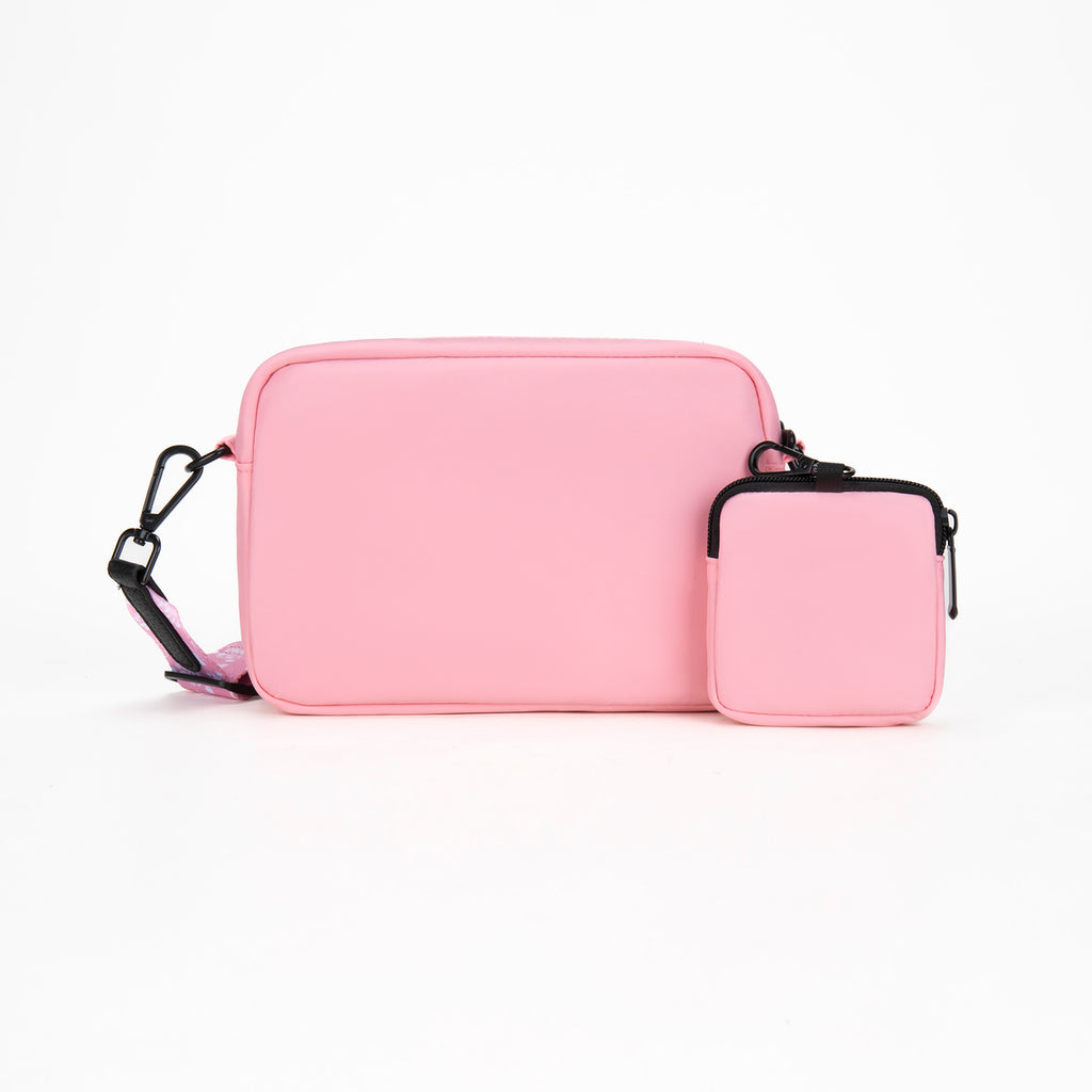 Pink crossbody bag with a smaller pouch on a white background