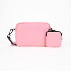 Pink crossbody bag with a smaller pouch on a white background
