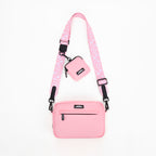 Pink crossbody bag with a matching pouch on a white background