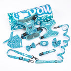 A collection of dog bandana and accessories in matching designs, including a bow tie, leash, and harness in a teal and white floral pattern.